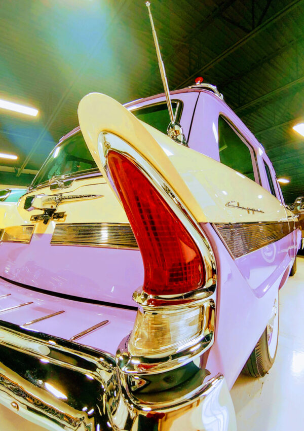 Pink and yellow antique auto with fins