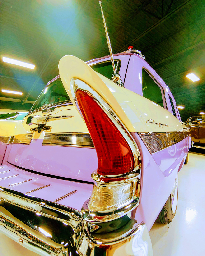 Pink and yellow antique auto with fins